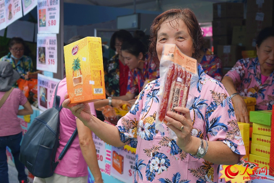 商户热情展示特色食品。人民网 实习生王悦 摄