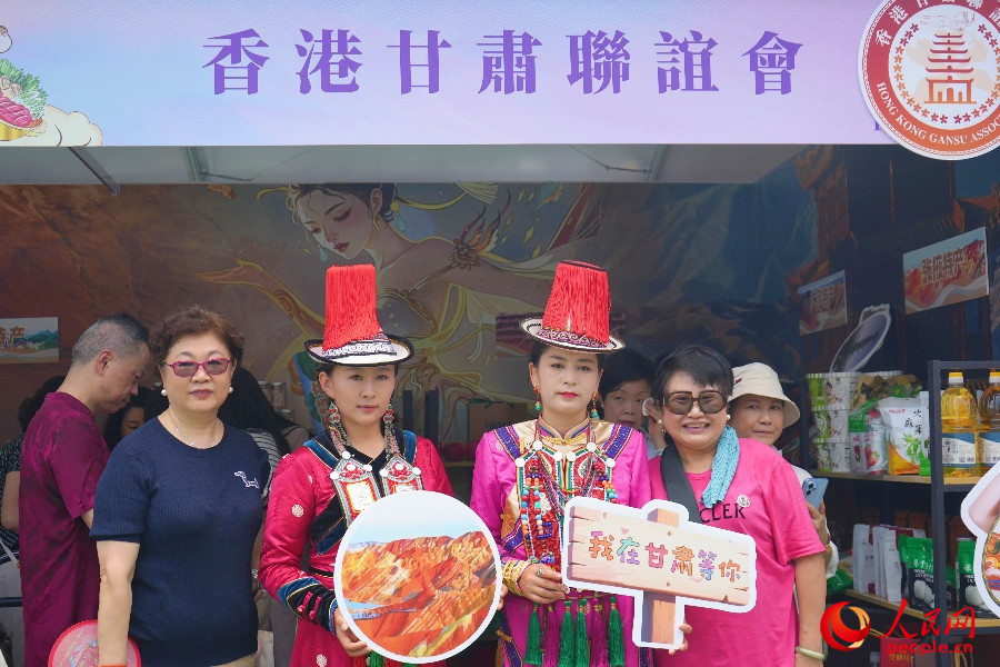 市民与身着民族服饰的工作人员合影。人民网 实习生王悦 摄