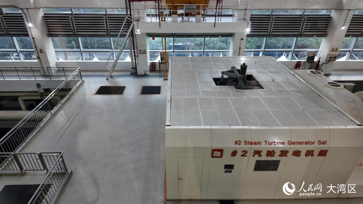 透过展厅玻璃可看到的巨大发电机组。 人民网 周锦佳摄