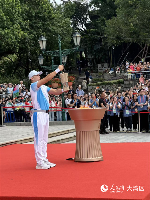 图为收火仪式上，火种护卫将火种引回火种灯并护送广州，参与在广东奥林匹克体育中心举行的融火仪式。人民网记者 富子梅摄