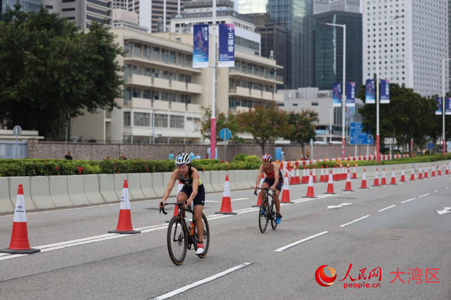 铁人三项女子个人赛自行车路线以中环商业区为背景，途经政府总部、立法会综合大楼、香港摩天轮等。人民网记者 冯学知摄