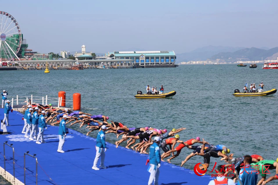 铁人三项男子个人赛参赛选手跳入维多利亚港，开始游泳项目的竞逐。人民网记者 冯学知摄