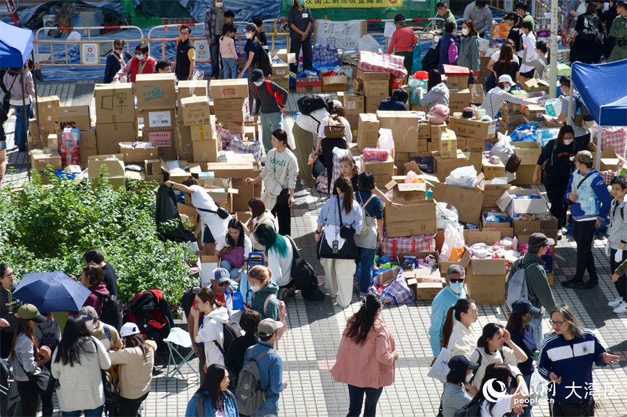 在宏福苑附近的广福邨公众活动平台上，义工和热心市民正在搬运分发各类物资。人民网 吴宇扬扬摄