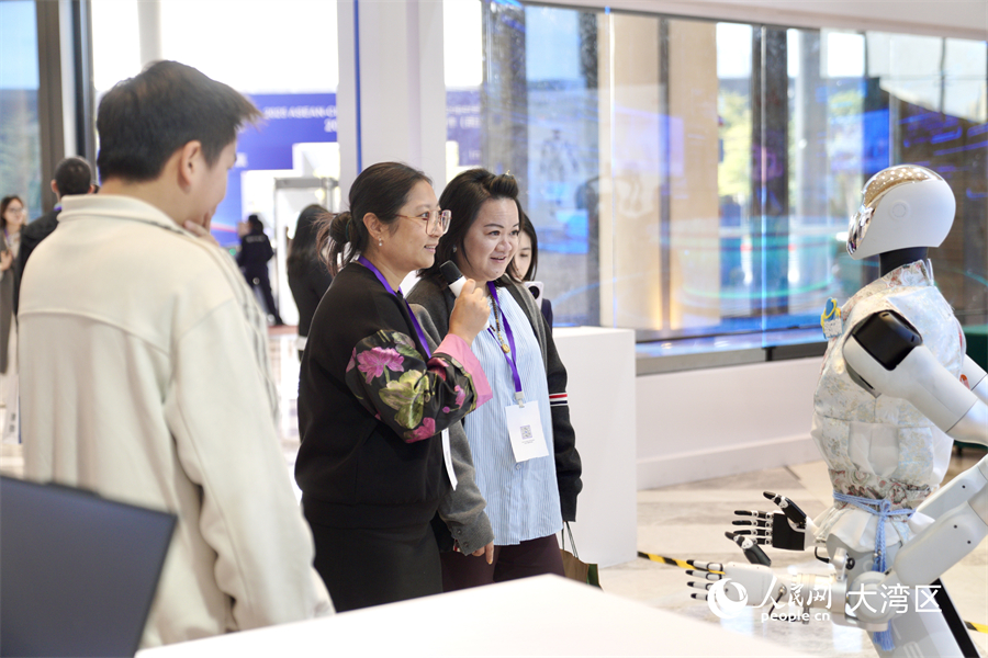 参会嘉宾在2025大湾区—东盟经济合作（前海）论坛现场的产品展区内听取讲解并参与互动。人民网记者 许峥摄