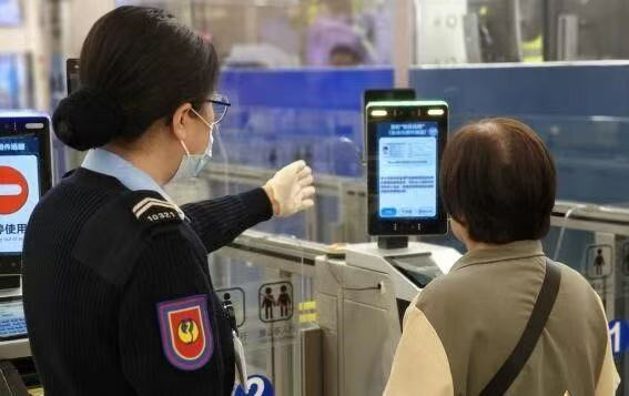 图为工作人员指导通关人士登记使用“刷脸”模式。澳门特区治安警察局供图