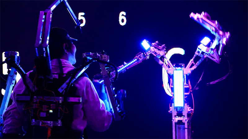 在AI互动装置《一路顺风》中，参与者穿戴专属设备与机器人翩然共舞。人民网 吴宇扬扬摄