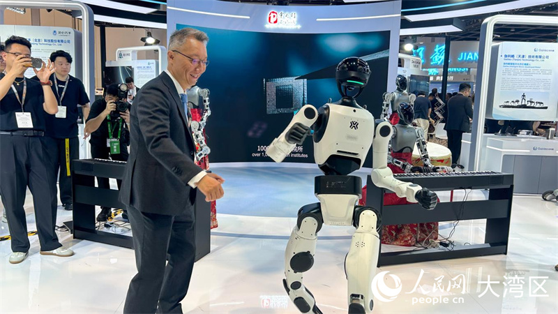 图1.参展观众与机器人互动共舞。人民网 余颖摄