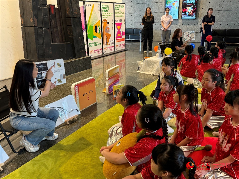 图为活动现场由老师带领同学们读绘本。人民网记者 富子梅摄