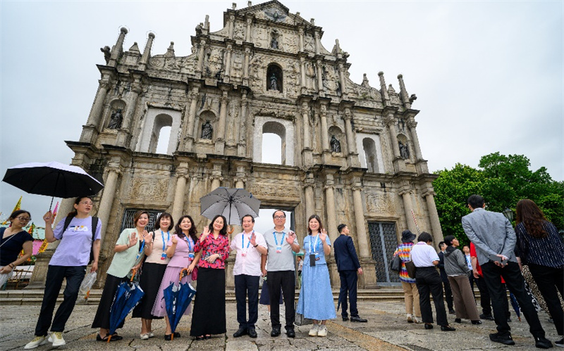 图为与会代表们纷纷在大三巴牌坊留影。 澳门特区政府新闻局供图