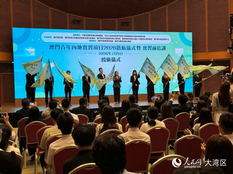 图为吴惠娴为澳门实习学生代表授旗。人民网记者 富子梅摄