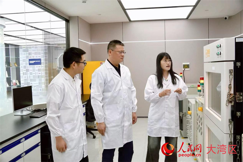 珈钠能源创始人兼首席科学家曹余良（中）与同事交流。人民网 韩宇轩摄