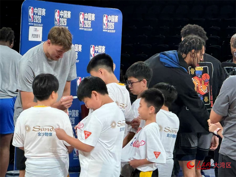 图为NBA球员爽快地为孩子们在球衣上签名留念。人民网记者 富子梅摄