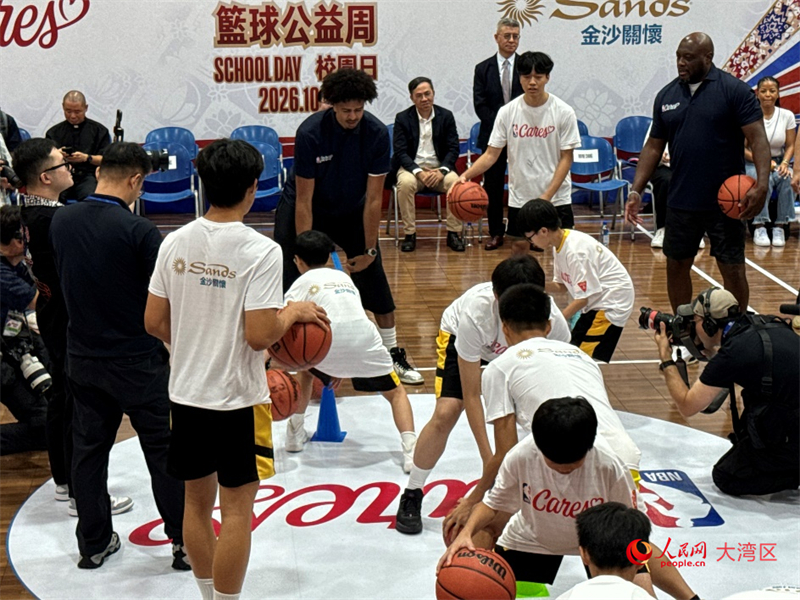 图为米奇‧里奇蒙德（右）与粤华中学篮球队员们交流球技。人民网记者 富子梅摄