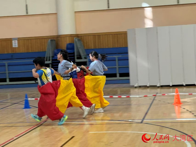 图为小学组的趣味项目比赛，同学们与特殊教育同伴一起快乐奔跑。人民网记者 富子梅摄