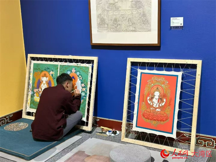这是10月20日在深圳美术馆拍摄的“梵韵丹青——热贡娘本唐卡艺术展”唐卡创作现场。唐卡是国家级非物质文化遗产，本次展览集中展现热贡唐卡独有的绘画技法，助力民族传统艺术的传播与交流。人民网 河贞美摄