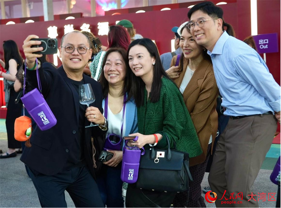 市民与游客在展位前举杯合影。人民网 张雨洁摄