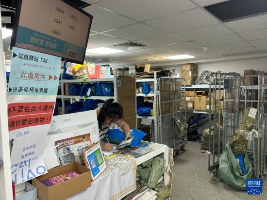 6月16日，工作人员在香港一快递包裹自提点忙碌。新华社发（郭辛摄）