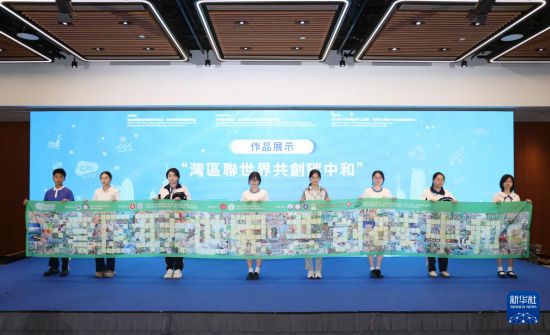 10月29日，参与活动的学生展示“湾区联世界 共创碳中和”作品。新华社发