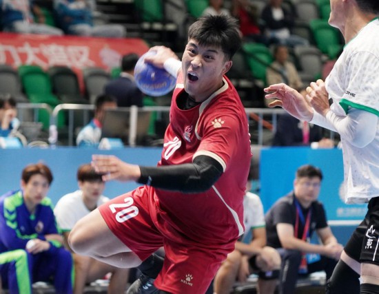 11月3日，山西队球员刘文东（左）在比赛中进攻。当日，在香港启德体艺馆举行的第十五届全国运动会男子手球预赛B组比赛中，山西队33比32战胜山东队。新华社发 （王申 摄）
