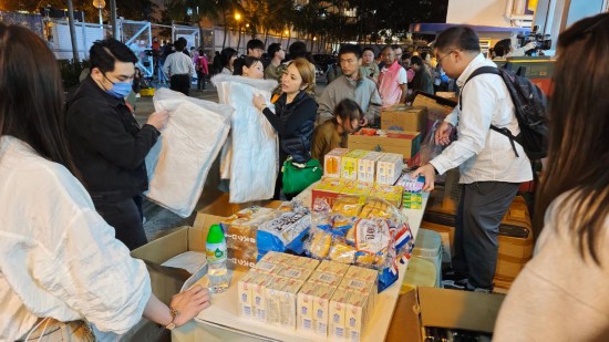  11月26日，受火灾影响的居民在跨部门援助站领取救援物资。新华社记者 陈铎 摄