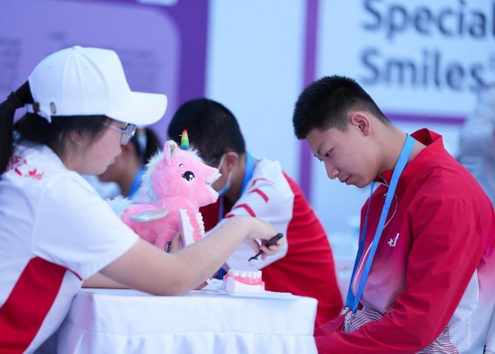 12月8日,在广东省中山市体育馆副馆,工作人员为特奥运动员普及护齿知识。新华社记者 杨晨光 摄