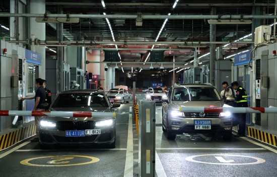 12月23日零时，“粤车南下”入境香港市区的首批通关车主在“一站式”通道办理通关手续。新华社记者 黄国保 摄