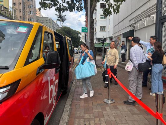 宏福苑受灾居民在庇护中心出来后，乘坐停靠在香港大埔社区会堂外的义载车辆（2025年12月2日摄）。新华社发（许淑敏摄）