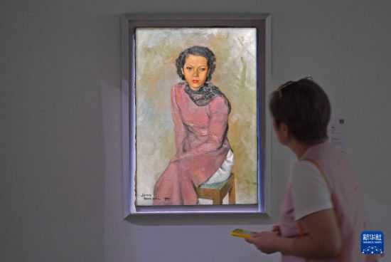 3月24日，一名女士在佳士得香港2026春季拍卖预展上观赏梁春尔的作品《女士肖像》。新华社记者陈铎摄