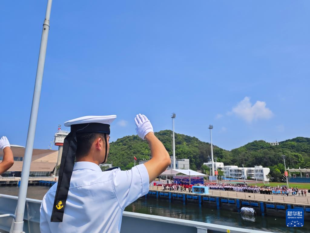 7月7日，湛江舰驶离昂船洲军营码头，士兵分区列队向前来送行的人群挥手告别。新华社发（冯丽 摄）