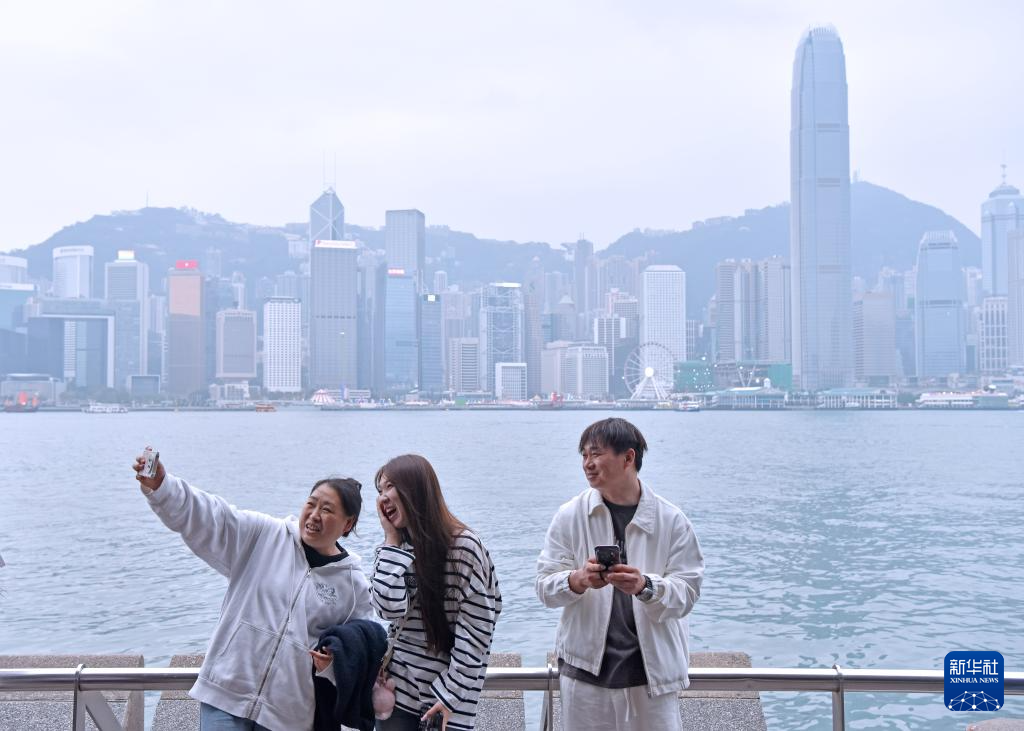 2月17日,游客在香港尖沙咀海滨自拍合影。新华社记者 陈铎 摄