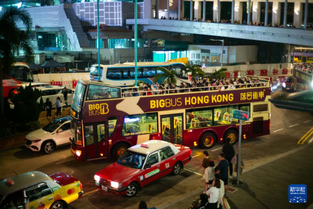 2月20日,在香港中环码头外,游客乘坐“落日飞车”游览。新华社记者 朱炜 摄
