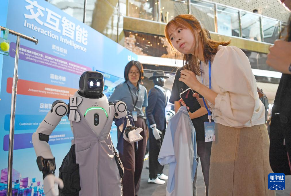 5月12日，与会者与一款智元机器人互动交流。 新华社记者 陈铎 摄